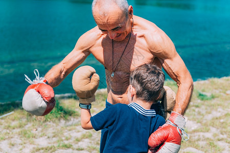 小拳手和高级教练在湖边拳箱图片