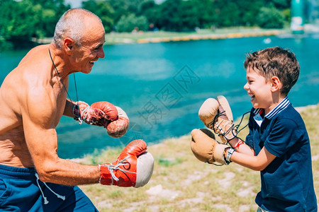 拳击手套小男孩在湖边跟爷练拳背景