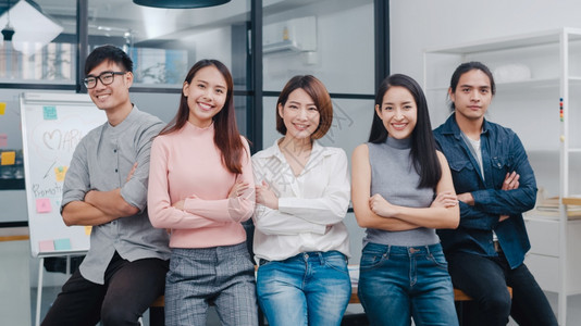 亚洲青年创作团体中聪明的随意穿戴微笑在有创意的办公室工作场所交叉手腕不同的亚洲男女在启动时齐心合力同事团队精神概念图片