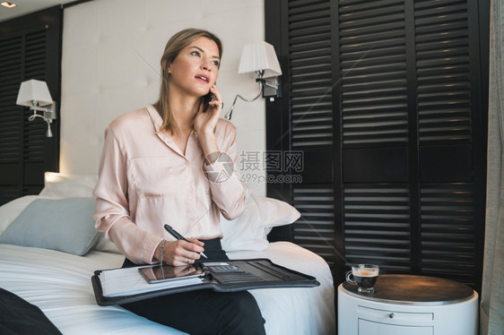 年轻女商人在酒店房间打电话的肖像商业旅行概念图片