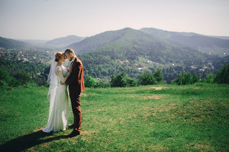 美丽的新婚夫妇在夏天阳光明媚的白在山上玩耍美丽的新婚夫妇在欢笑真正的感情浪漫的时刻快乐新婚娘和郎在夏日阳光明媚的子里在山上玩耍图片