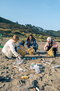 一群女志愿者在海滩上捡垃圾图片