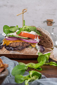 健康的素食汉堡新鲜蔬菜和酸奶酱在生锈的厨房柜台顶部图片