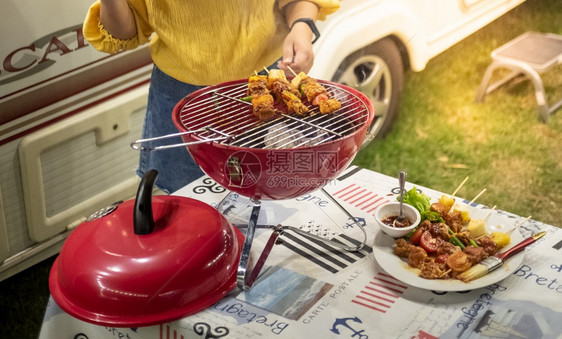 朋友做烧烤BBQ在大自然的热火上烧烤晚的宴图片