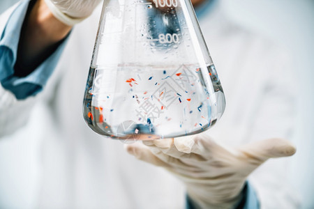 微塑料实验室分析科学家观察有水样的瓶子中微塑料或小粒图片