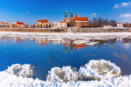 波兰兹南大教堂的全景和波兰兹南冬季阳光明日沃塔河上的波兹南大教堂和冰流图片