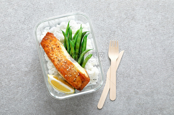 装有烤鲑鱼片大米和绿豆的午餐盒图片