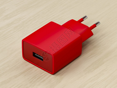 用木制桌上USB端口装在木制桌上的红色智能手机充电器图片