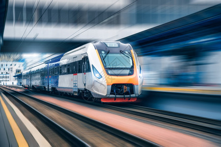 日落时在火车站开动高速现代城市间客运列车在铁路平台上运动模糊效应工业欧洲铁路运输工业图片