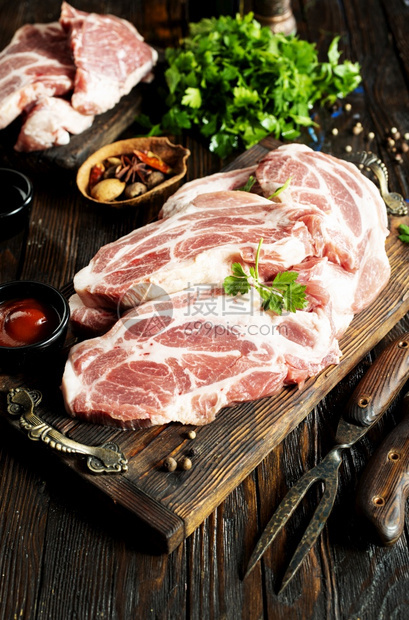 木板上的生肉桌配香料的生肉图片