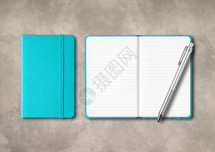 水蓝色闭着和开线笔记本有混凝土背景上隔离的Mockup水蓝色闭着和开线笔记本有混凝土背景上的笔图片