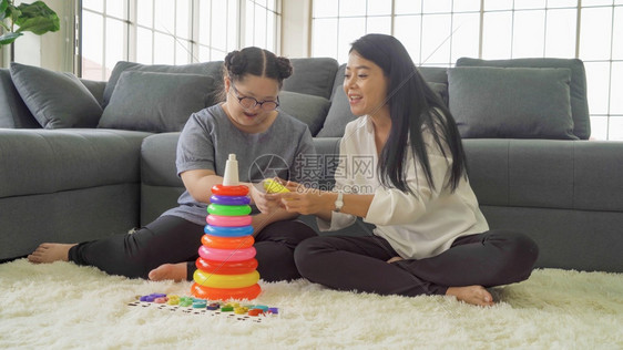 亚洲母亲教她女儿使用多彩的堆叠环塔教育研究玩具实用技能的家庭学习时间在科罗纳大流行的隔离中在家里学习庭时间图片