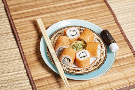 寿司卷配有筷子和豆汁图片