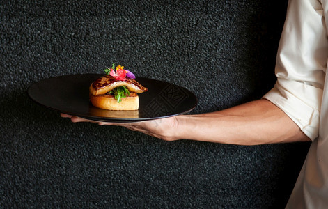 FoieGrass提供烤面包和绿色沙拉黑深墙背景图片