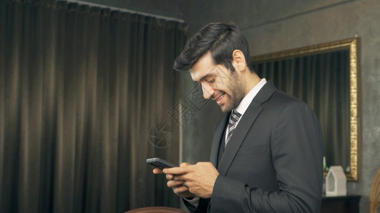 中东部人CEO在家工作使用移动智能手机在技术设备通信概念中传递短信图片