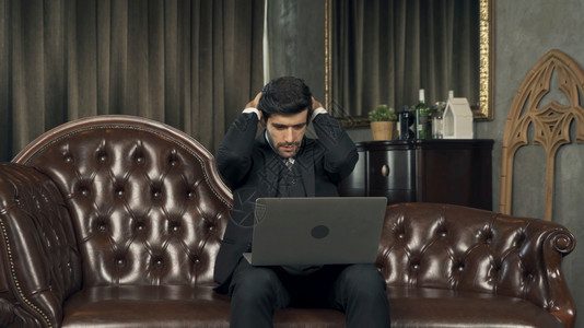可悲的中东商人首席执行官晚上在家加班工作思考电脑笔记本电脑的问题并患有隔离中的抑郁症图片