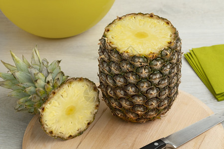 新鲜的成熟热带菠萝在切割顶端的板上图片