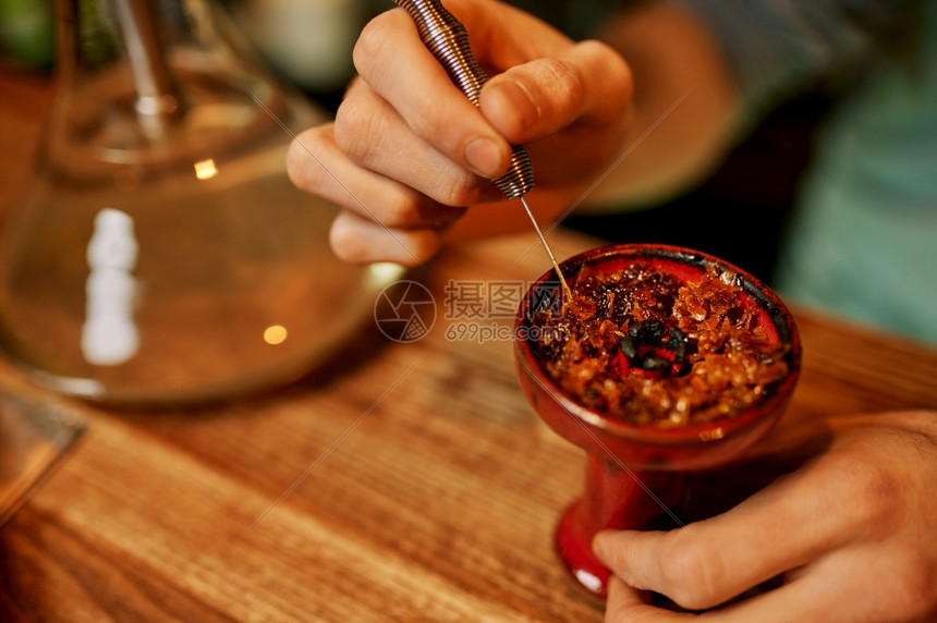 Hookah制造者准备在酒吧吸烟Shisha吸烟传统雾文化草芳香用于放松与bong人休息Hookah制造者准备在酒吧吸烟Hook图片