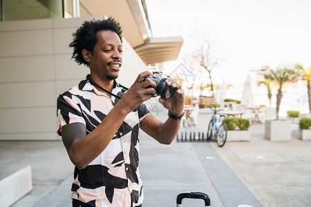 Afro旅游男子在街上户外散步时用照相机拍的肖像图片