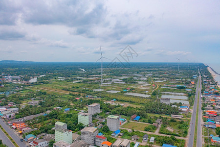 泰国NakhonSiThammarat市风力涡轮机与拥有海空线的住宅建筑空中观测亚洲城市建筑景观背图片