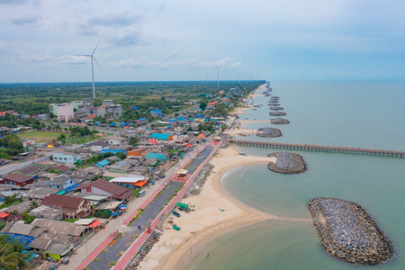 泰国NakhonSiThammarat市风力涡轮机与拥有海空线的住宅建筑空中观测亚洲城市建筑景观背图片