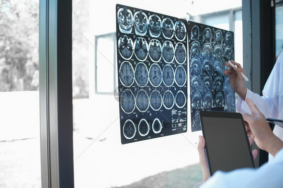 在研讨会或科罗纳医院的新冠癌症保健中用药片和文件对白制服长袍大衣教育和医学概念进行X光筛查的医生进行专业检查图片
