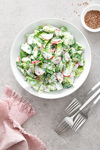 新鲜蔬菜沙拉包括绿色生菜萝卜和黄瓜加绿洋葱和希腊酸奶图片