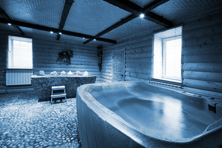 在美丽的木制桑拿浴缸中用水洗澡图片