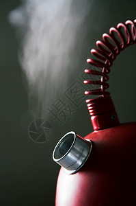 黑暗背景的红沸腾茶壶图片