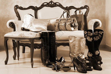 女鞋靴子和手袋放在沙发和枕头上图片