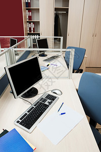 现代办公室玻璃后面的电脑图片