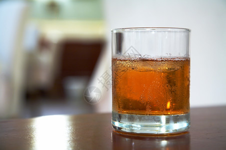 用冰在桌上的威士忌杯图片