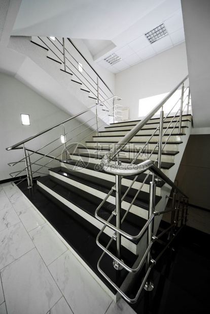 现代建筑中装有钢铁扶手的大理石楼梯图片