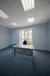 现代办公室一扇窗口的椅子和桌图片