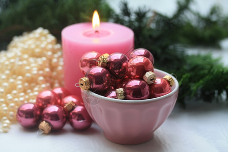 粉色蜡烛和有小圣诞球的碗图片