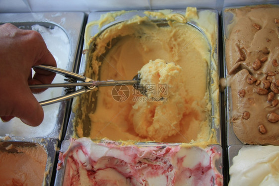 拿勺子准备取出奶黄色的冰淇淋图片
