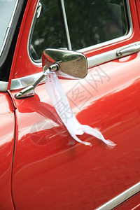 红色旧车当结婚时镜子上有白丝带图片