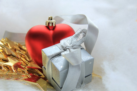 心丝带银色圣诞节礼物和红心以圣诞节为形状的装饰品背景