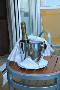 一瓶香槟和杯子在水桶里等着送货图片