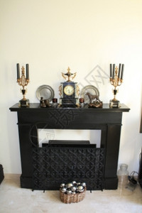 黑色大理石壁炉有古董钟和匹配的蜡烛手图片