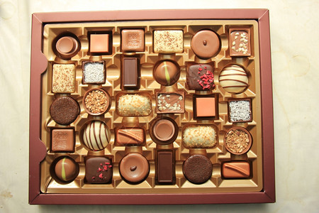 以不同形状和口味装在礼物盒里的美味巧克力图片