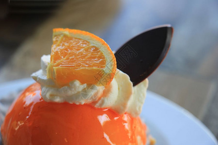 新鲜橙子慕斯甜点加奶油和巧克力装饰品图片