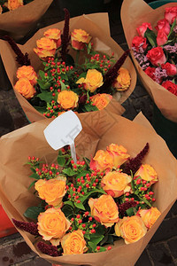 在市场中用纸包成的玫瑰花束背景图片