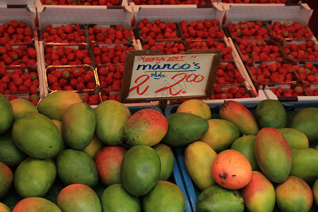 市场摊子草莓和芒果上的新鲜水荷兰文标签甜芒果2欧元图片