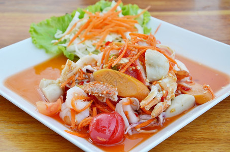 泰国菜木制桌上的辣味海鲜沙拉图片