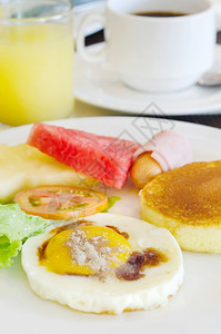 早餐全煎饼蛋火腿和香肠新鲜蔬菜和水果热咖啡汁图片