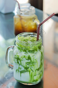 把冰牛奶绿茶和吸管放在桌上冰牛奶绿茶图片