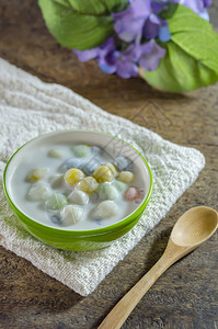 勺子上的芋圆椰奶甜品在白色桌布上背景