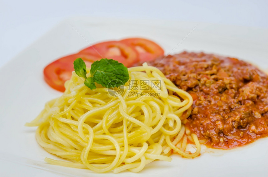 SpaghettiBolognese膳食面粉配有叶和西红柿图片