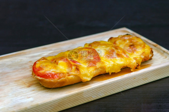 土制的法国面包卷加满新鲜西红柿融化的切达Mozzarella和Parmesan图片